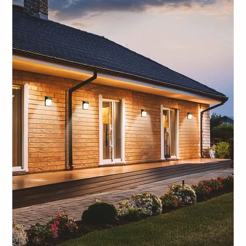 kinkiet zewnętrzny oświetlający elewację domu nocą